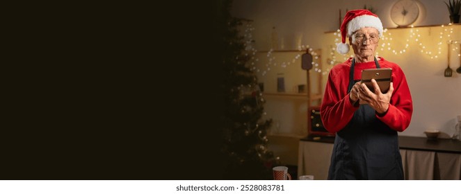 Cheerful retired homeowner man, food blogger, chef cooking bakery in Christmas kitchen alone, using digital tablet browsing recipe ginger cookies on Internet. - Powered by Shutterstock