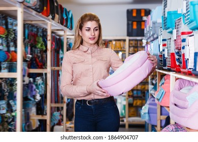 Cheerful Saleswoman Offering Pet Bed In Pet Store