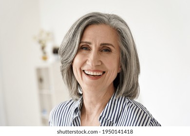 Cheerful satisfied 50s mature woman laughing looking at camera at home. Happy sophisticated classy mid age older gray-haired lady with white teeth dental smile posing for close up headshot portrait. - Shutterstock ID 1950141418