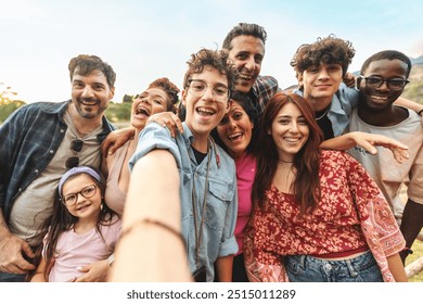 Cheerful selfie of diverse group of friends and family. Multicultural gathering outdoors - Genuine happiness and inclusivity - Unity, friendship, and joyful moments across generations and ethnicities. - Powered by Shutterstock