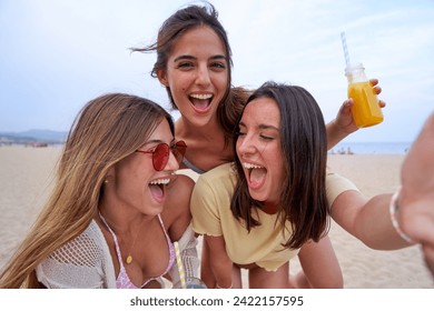 Cheerful selfie of three women on the beach playing doing piggyback. Female friends with smoothies in summertime having fun. - Powered by Shutterstock