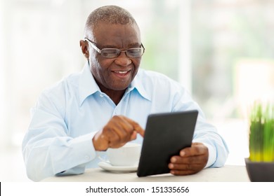 Cheerful Senior African American Man Using Tablet Computer At Home