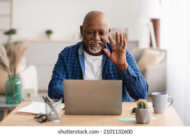 Cheerful Senior Black Male Video Calling Waving Hello To Laptop Computer Communicating Online Sitting At Workplace In Office Indoor. Modern Remote Communication Concept