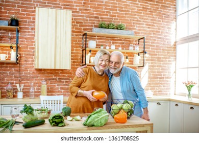 Cheerful Senior Couple Cooking Food With Healthy Fresh Ingredients On The Kitchen At Home. Concept Of Healthy Nutrition In Older Age