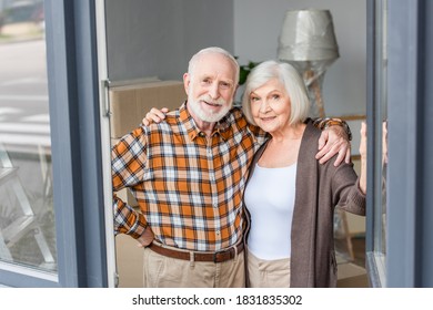 cheerful senior couple embracing each other in new house