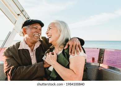 Cheerful senior couple enjoying a Ferris wheel by the Santa Monica pier