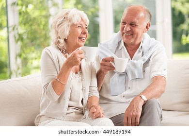 Cheerful senior couple having delicious morning coffee indoor - Powered by Shutterstock