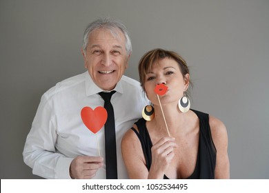 Cheerful Senior Couple With Photobooth Props, Isolated