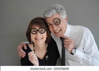 Cheerful Senior Couple With Photobooth Props, Isolated