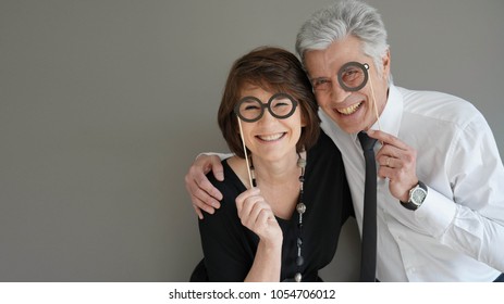 Cheerful Senior Couple With Photobooth Props, Isolated