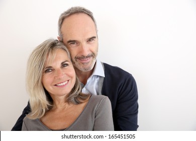 Cheerful senior couple standing on white background