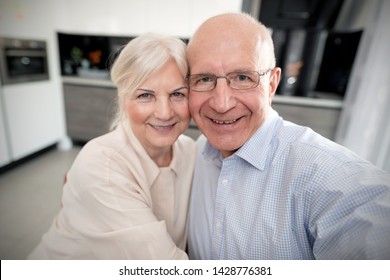 Cheerful Senior Couple Taking Selfie At Home