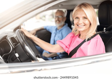 Cheerful senior couple with the woman driving and the man enjoying the ride, embodying a happy retired married life on the road - Powered by Shutterstock