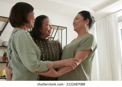 Cheerful Senior Friends Hugging When Having Small Party At Home After Not Seeing Each Other For A Long Time Due To Lockdown