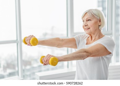 Cheerful Senior Lady Exercising With Weights