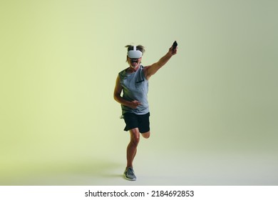 Cheerful Senior Man Winning A Virtual Reality Fitness Game In A Studio. Athletic Senior Man Celebrating His Victory While Wearing A Virtual Reality Headset.