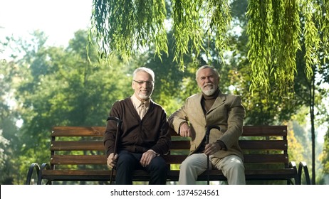 Cheerful Senior Men With Walking Sticks Sitting On Bench, Happy Life In Old Age