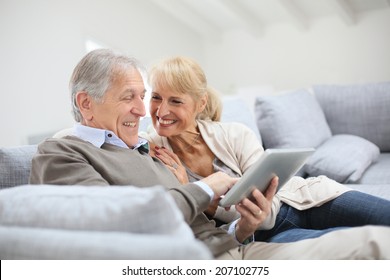 Cheerful Senior People Websurfing On Internet With Tablet