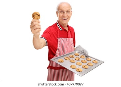 Cheerful senior showing his homemade chocolate chip cookies isolated on white background