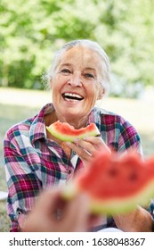 Cheerful Senior Woman Eating Melon At The Park In Summer On A Trip