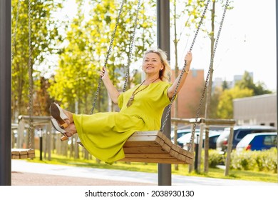 Cheerful Senior Woman On A Swing At A Park