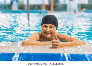 cheerful senior woman in the pool showing thumb-up, happy senior people concept. High quality photo - Powered by Shutterstock