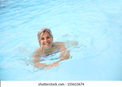 Cheerful senior woman in swimming-pool