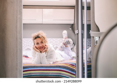 Cheerful Serene Young Adult Woman Laying In The Bedroom Inside A Modern Camper Van Motor Home. Happy Female People Enjoying Travel Vacation And Vanlife Lifestyle. Living Off Grid Alternative Life