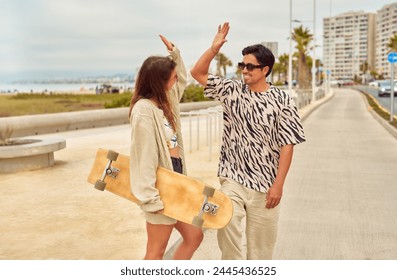 cheerful skateboard couple doing the high five gesture on the street - Powered by Shutterstock