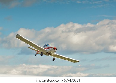 Cheerful  Small Plane In The Blue Cloudy Sky