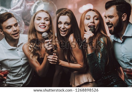 Cheerful. Smile. Smiling Girl. Singing Songs. Beautiful Girls. Friends at Karaoke Club. Karaoke Club. Celebration. Waiting Men. Young People. Party Maker. Girls Sing. Trendy Nightclub. Have Fun.