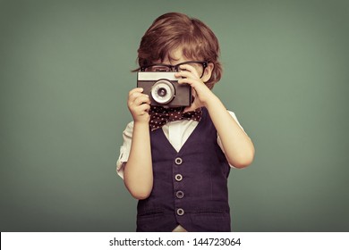 Cheerful  smiling  child (boy) holding a instant camera - Powered by Shutterstock