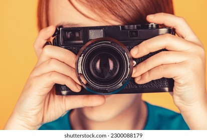 Cheerful smiling child holding a cameras. Little boy on a taking a photo using a vintage camera. Child in studio with professional camera. Boy using a cameras. Baby boy with camera. - Powered by Shutterstock