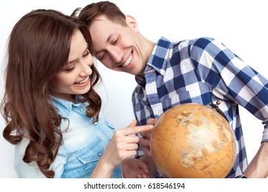 Cheerful Smiling Couple Pointing At The Globe. Horizontal Studio Shot.