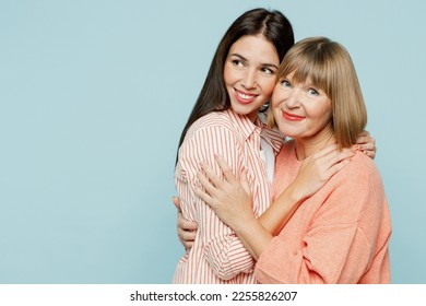 Cheerful smiling elder parent mom with young adult daughter two women together wear casual clothes hugging cuddle look camera aside on area isolated on plain blue cyan background. Family day concept - Shutterstock ID 2255826207