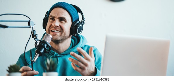 Cheerful And Smiling Host Streaming His Audio Podcast At Small And Cozy Home Broadcast Studio