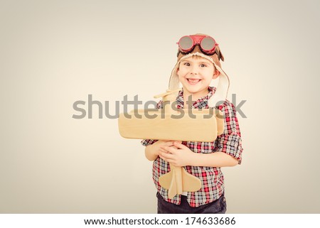 Cheerful smiling kid (boy)l in helmet on a green background. Vintage pilot (aviator) concept