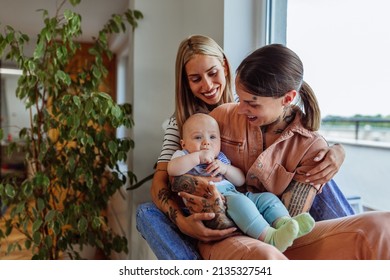 Cheerful And Smiling Lesbians Are Sharing Beautiful Moments With Their Baby Boy At Home