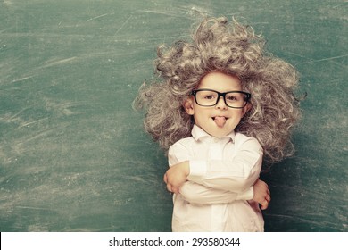 Cheerful Smiling Little Kid (boy) Against Chalkboard. Looking At Camera. Little Einstein Style. School Concept