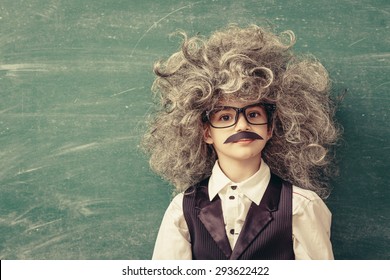 Cheerful Smiling Little Kid (boy) Against Chalkboard. Looking At Camera. Little Einstein Style. School Concept