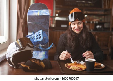 Cheerful Smiling Woman With Ski Goggles On Her Face In Bar.