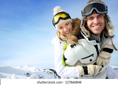 Cheerful snowboarder holding girlfriend on his back - Powered by Shutterstock