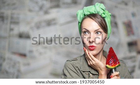 Cheerful soldier with a candy on grey