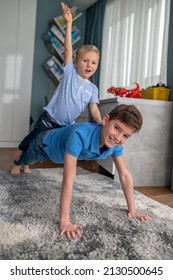 Cheerful Sporty Boy Exercising With His Younger Sibling