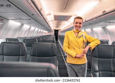 Cheerful stewardess standing in aircraft passenger salon - Shutterstock ID 2136432761