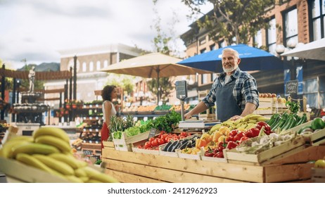 Cheerful Street Vendor Running a Small Farm Market Business, Selling Sustainable Fruits and Vegetables. Happy Middle Aged Man Waiting for Customers in the Morning - Powered by Shutterstock