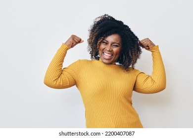 Cheerful strong woman flexing muscles against white background