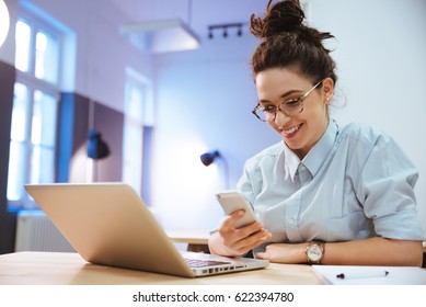 Cheerful Student Girl Using Mobile Device In Coworking Space