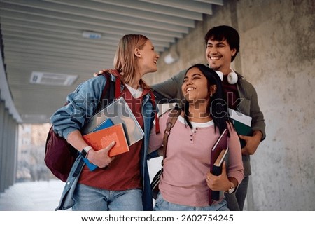 Cheerful students having fun while going at the university.