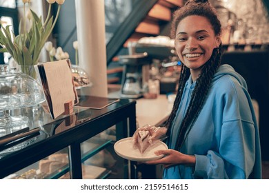 Cheerful Stylsih  Female Bartender Holding Plate With Piece Of Cake At Counter. Portrait.